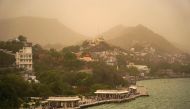 Tourists gather along the banks of Anasagar Lake during a duststorm in Ajmer on May 28, 2023. (Photo by Himanshu Sharma / AFP)
