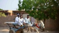 People ride a donkey-pulled cart along a street in Omdurman, Khartoum's twin city, on May 28, 2023, amid ongoing violence between the forces of two rival Sudanese generals. (Photo by AFP)