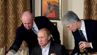 Yevgeny Prigozhin (L) assists Russian Prime Minister Vladimir Putin during a dinner with foreign scholars and journalists at the restaurant Cheval Blanc on the premises of an equestrian complex outside Moscow November 11, 2011. REUTERS/Misha Japaridze/File Photo

