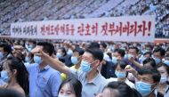 In this photo taken on June 25, 2023, residents of Pyongyang hold a banner that reads 