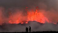 People watch flowing lava during an volcanic eruption near Litli Hrutur, south-west of Reykjavik in Iceland on July 10, 2023. Photo by Kristinn Magnusson / AFP