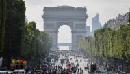 Pedestrians walk on Champs-Elysees avenue in Paris, on July 2, 2023, a day after protesters took to the street and clashed with police on an iconic street popular with tourists during a protest against the police killing of a 17-year-old teenage boy. (Photo by Ludovic MARIN / AFP)

