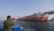 A man snaps a picture of the beleaguered Yemen-flagged FSO Safer oil tanker in the Red Sea off the coast of Yemen's contested western province of Hodeida on July 15, 2023. (Photo by Mohammed Huwais / AFP)