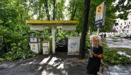 Fallen tree branches cover a gas station in Milan on July 25, 2023 after an overnight rainstorm hit the city. (Photo by Piero Cruciatti / AFP)