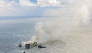 An aerial photograph of emergency boats extinguishing a fire aboard the Panamanian-registered car carrier cargo ship Fremantle Highway. Photo by Flying Focus / ANP / AFP
