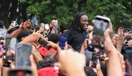 People gather around and cheer for Kai Cenat (C) as members of the NYPD respond to thousands of people gathered for a 