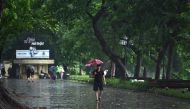 A man walks with an umbrella during rainfall in Hanoi on August 4, 2023. Photo by Nhac NGUYEN / AFP