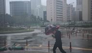 A man uses his umbrella in the southeastern port city of Busan on August 10, 2023, as Typhoon Khanun approaches. Photo by Anthony WALLACE / AFP
