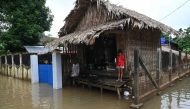 A girl stands outside her house above a flooded street in Bilin township, in Myanmar's Mon state, on August 11, 2023. (Photo by Sai Aung Main / AFP)