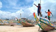 Young boys play on a pirogue in Fass Boye on August 17, 2023 after a pirogue capsized off the coast of Cape Verde. (Photo by SEYLLOU / AFP)
