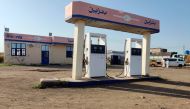 People stand next to an empty petrol station amid soaring fuel prices in Sudan's eastern city of Gedaref on August 19, 2023. (Photo by AFP)