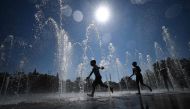 Children cool off as they run through a public fountain in Colmar, eastern France, on August 21, 2023, as France experiences a late summer heatwave. (Photo by Sebastien Bozon / AFP)