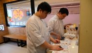 Customers look at the takeaway menu in a Japanese Sushi restaurant in Hong Kong on August 22, 2023. Photo by Peter PARKS / AFP