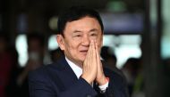 Former Thai Prime Minister Thaksin Shinawatra greets his supporters after landing at Bangkok's Don Mueang airport on August 22, 2023. (Photo by Manan Vatsyayana / AFP)