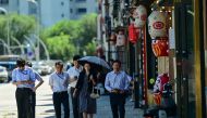 People walk past a Japanese restaurant near the Japanese embassy in Beijing on August 29, 2023.  (Photo by Pedro Pardo / AFP)

