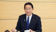 This handout photo taken and received from the Cabinet Public Relations Office via Jiji Press on August 30, 2023 shows Japan's Prime Minister Fumio Kishida posing as he eats seafood from Fukushima prefecture at the prime minister's office in Tokyo. (Photo by Handout / various sources / AFP)