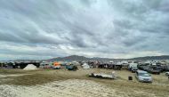 Camps are set on a muddy desert plain on September 2, 2023, after heavy rains turned the annual Burning Man festival site in Nevada's Black Rock desert into a mud pit. (Photo by Julie Jammot / AFP)