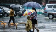 People hold umbrellas while walking on the street in the rain in Keelung after Typhoon Haikui hits Taiwan on September 4, 2023. (Photo by I-Hwa Cheng / AFP)