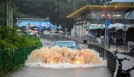 A motorist drives through floodwaters on Lantau Island in Hong Kong on September 8, 2023. Photo by Peter PARKS / AFP