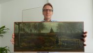 An handout picture released by Dutch art detective Arthur Brand shows a portrait of him posing with the painting title 