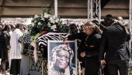 A member of the Buthelezi clan carries a photograph next to the coffin of the Zulu prince Mangosuthu Buthelezi, traditional prime minister of the Zulu Monarch and Nation and founder of the Inkatha Freedom Party (IFP), in Ulundi, South Africa on September 16, 2023. (Photo by RAJESH JANTILAL / AFP)

