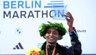 Ethiopia's Tigist Assefa celebrates on the podium with her trophy after winning the women's race of the Berlin Marathon on September 24, 2023 in Berlin, Germany.  (Photo by Tobias SCHWARZ / AFP)