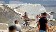 A man carries away a Palestinian killed in an Israeli airstrike at the Erez crossing between Israel and the northern Gaza Strip, on October 7, 2023. (Photo by Bashar Taleb / AFP)