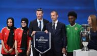 Gareth Bale (3rdL), flanked by UEFA president Aleksander Ceferin (C), poses with fans as they hold the pennant after UK and Ireland were elected to host the Euro 2028 fooball tournament. (Photo by Fabrice Coffrini / AFP)