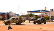 A patrol vehicle of the Nigeiren Gendarmerie (L) escorts a French Army military vehicle belonging to a convoy of French troops (R) as they cross the Lazaret district in Niamey on October 10, 2023. (Photo by AFP)