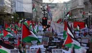 People holding placards and flags of Palestine take part in a 'March For Palestine', part of a pro-Palestinian national demonstration, in London on October 14, 2023. (Photo by Adrian Dennis / AFP)