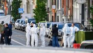 Belgian police officers from the forensic service gather in the street in the Schaerbeek area of Brussels on October 17, 2023. (Photo by John Thys / AFP)
