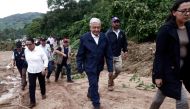Mexican President Andres Manuel Lopez Obrador (C) and members of his cabinet walk amid debris as they visit the Kilometro 42 community, near Acapulco, Guerrero State, Mexico, after the passage of Hurricane Otis, on October 25, 2023. Photo by Rodrigo OROPEZA / AFP