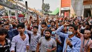 Garment workers block roads as they take part in a protest in Dhaka on November 1, 2023. (Photo by Munir Uz Zaman / AFP)