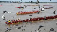 Pigeons fly past as participants row dragon boats during a competition as part of the Water Festival on the Tonle Sap river in Phnom Penh on November 26, 2023. (Photo by Tang Chhin Sothy / AFP)