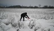 A local resident clears snow from a path after heavy snowfall, on the outskirts of Sofia on November 26, 2023. (Photo by Nikolay DOYCHINOV / AFP)
