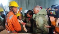 This handout picture released by the Uttarakhand's Department of Information and Public Relation (DIPR) and taken on November 28, 2023 shows a contruction worker (front 2L) interacting with Chief minister of Uttarakhand Pushkar Singh Dhami (C) following his rescue from inside the under construction Silkyara tunnel during a rescue operation for trapped workers after a section of the tunnel collapsed in the Uttarkashi district of India's Uttarakhand state. (Photo by Department of Information and Public Relation (DIPR) Uttarakhand / AFP) 