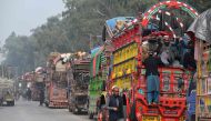 This photo taken on November 23, 2023 shows Afghan refugee on a truck after visiting the United Nations High Commissioner for Refugees (UNHCR) Azakhel Voluntary Repatriation Centre in Nowshera. More than 345,000 Afghans have returned to their country or been deported since Pakistan in October ordered undocumented migrants or those who have overstayed their visas to leave. (Photo by Farooq Naeem / AFP)