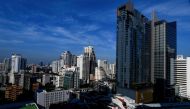 A general view shows a BTS commuter train as it passes with the backdrop of the Bangkok skyline on June 2, 2023. Photo by Manan VATSYAYANA / AFP

