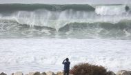 A person takes photos as large waves break near the beach on December 29, 2023 in Manhattan Beach, California. Mario Tama/Getty Images/AFP 