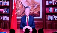 eople have their dinner at a restaurant as a screen broadcasts China's President Xi Jinping while delivering his New Year's speech in Beijing on December 31, 2023. (Photo by Pedro Pardo / AFP)
