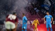 Napoli’s Italian goalkeeper Pierluigi Gollini walks on the pitch past a firework thrown by Napoli's supporters during the Italian Serie A football match Torino vs Napoli at the “Stadio Grande Torino” in Turin on January 7, 2024. (Photo by MARCO BERTORELLO / AFP)
