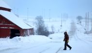 A person walks back to his home after checking the mailbo as a snowy and freezing cold weather system passes through the area on January 13, 2024, in Casey, Iowa.  (Photo by JOE RAEDLE / GETTY IMAGES NORTH AMERICA / Getty Images via AFP)
