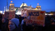 A participant holds up a placard during a demonstration against racism and far right politics in front of the Reichstag building in Berlin, Germany on January 21, 2024. (Photo by CHRISTIAN MANG / AFP)
