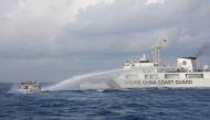 File: Handout photo taken and released on December 10, 2023 shows a China Coast Guard vessel using water cannon against the M/L Kalayaan chartered supply boat during a mission to deliver provisions at Second Thomas Shoal in disputed waters of the South China Sea. (Photo by Handout / Philippine Coast Guard / AFP)