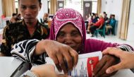 A blind woman is helped to cast her ballot at a polling station during Indonesia's presidential and legislative elections in Medan, North Sumatra on February 14, 2024. (Photo by Kartik BYMA / AFP)

