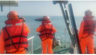 Handout photo taken on February 14, 2024, by the Taiwan Coast Guard shows Taiwanese Coast Guard staff surrounding an overturned Chinese speed boat near the Kinmen Islands. (Photo by Handout / Taiwan Coast Guard / AFP) 