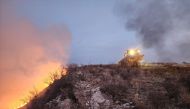 This handout picture courtesy of the Texas A&M Forest Service and taken on February 27, 2024, shows a Texas A&M Forest Service bulldozer building a containment line as it battles the Windy Deuce Fire in Moore County, Texas. (Photo by J. Griffin / Texas A&M Forest Service / AFP)