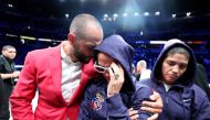 Amanda Serrano reacts as she leaves the ring with Most Valuable Promotions CEO Nakisa Bidarian after her fight was cancelled against Nina Meinke for Serrano's IBF, WBO and WBA featherweight women's titles at Coliseo de Puerto Rico on March 02, 2024 in Hato Rey, Puerto Rico. (Photo by AL BELLO / GETTY IMAGES NORTH AMERICA / Getty Images via AFP)
