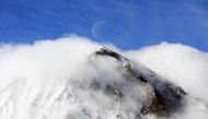 The moon sets over a peak in the Sierra Nevada mountain range during a blizzard in Big Pine, California on March 3, 2024. (Photo by David SWANSON / AFP)

