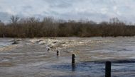 A bridge submerged by the flooded Gard river is pictured in Dions, on March 10, 2024 following heavy rain over south-eastern France. (Photo by Clement Mahoudeau / AFP)
 